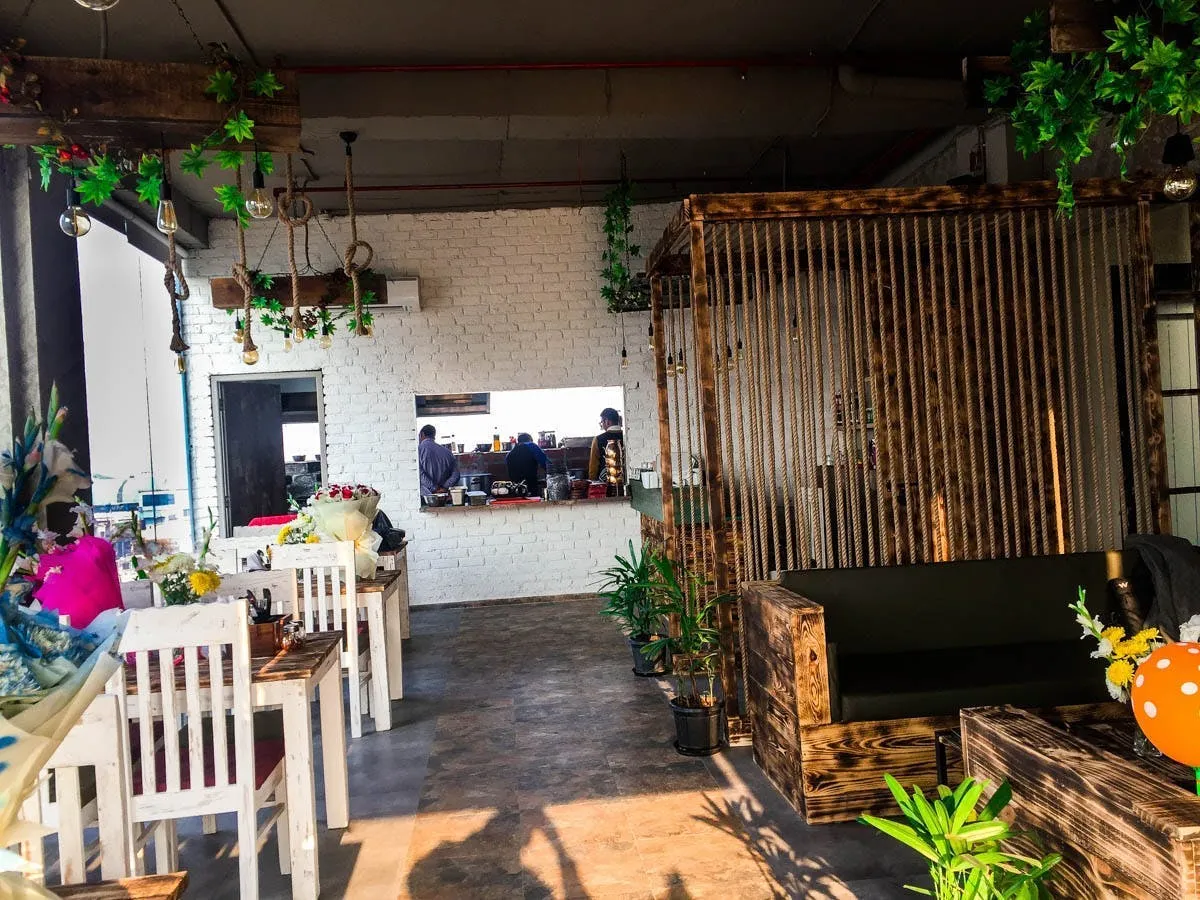 Cafe and restaurant interior in Noida with layered seating and warm hospitality lighting