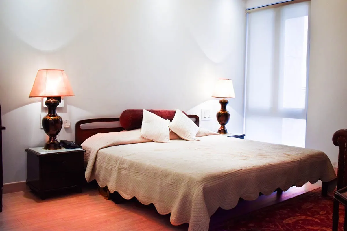 Luxury apartment living room in Heritage City Gurugram with curved sofa and timber wall detailing