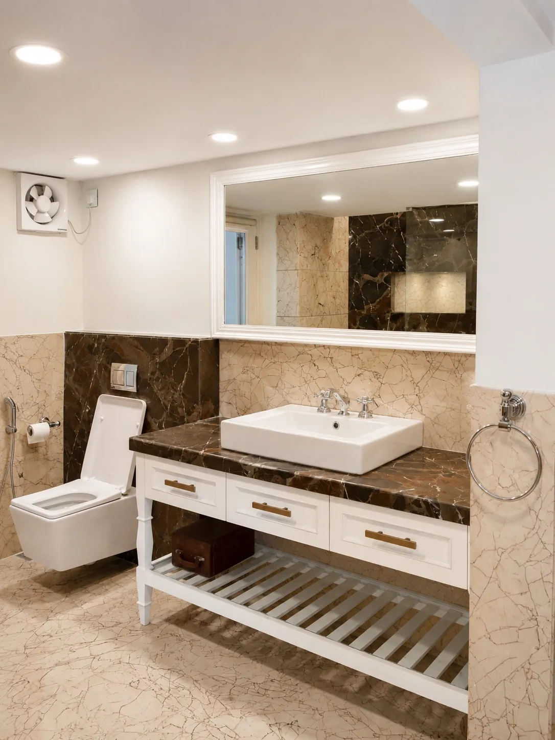 Bathroom clad in brown and cream marble with a white vanity, a rectangular vessel basin, and a large white-framed mirror