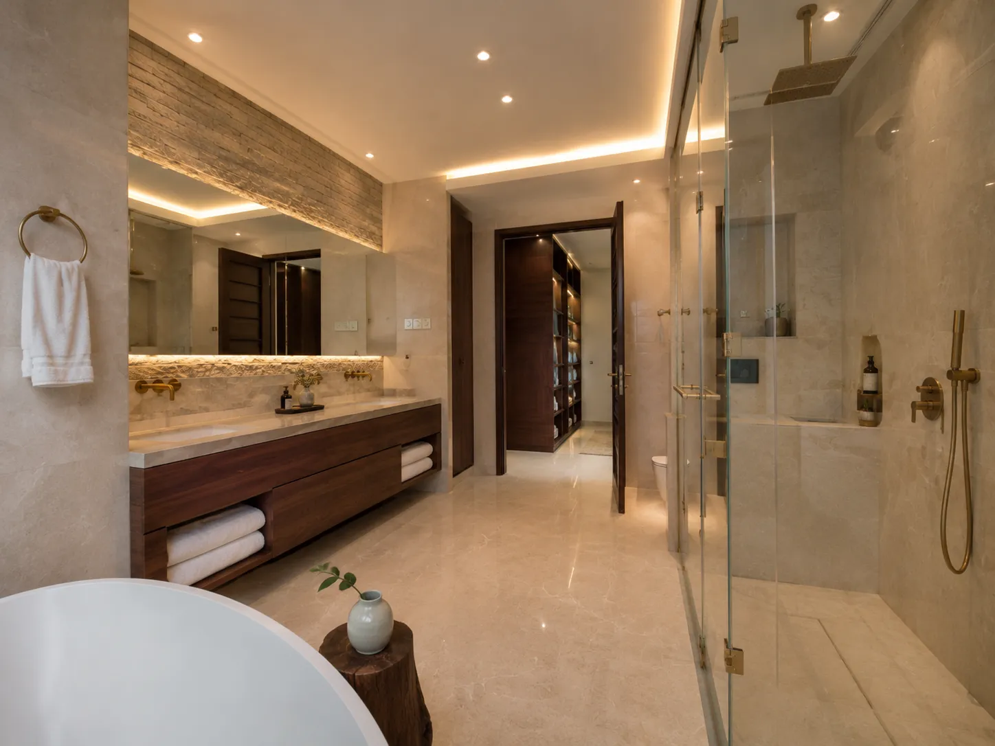 View of a luxury bathroom showing a glass shower enclosure with brass fixtures and an open door leading to a dark wood walk-in closet.