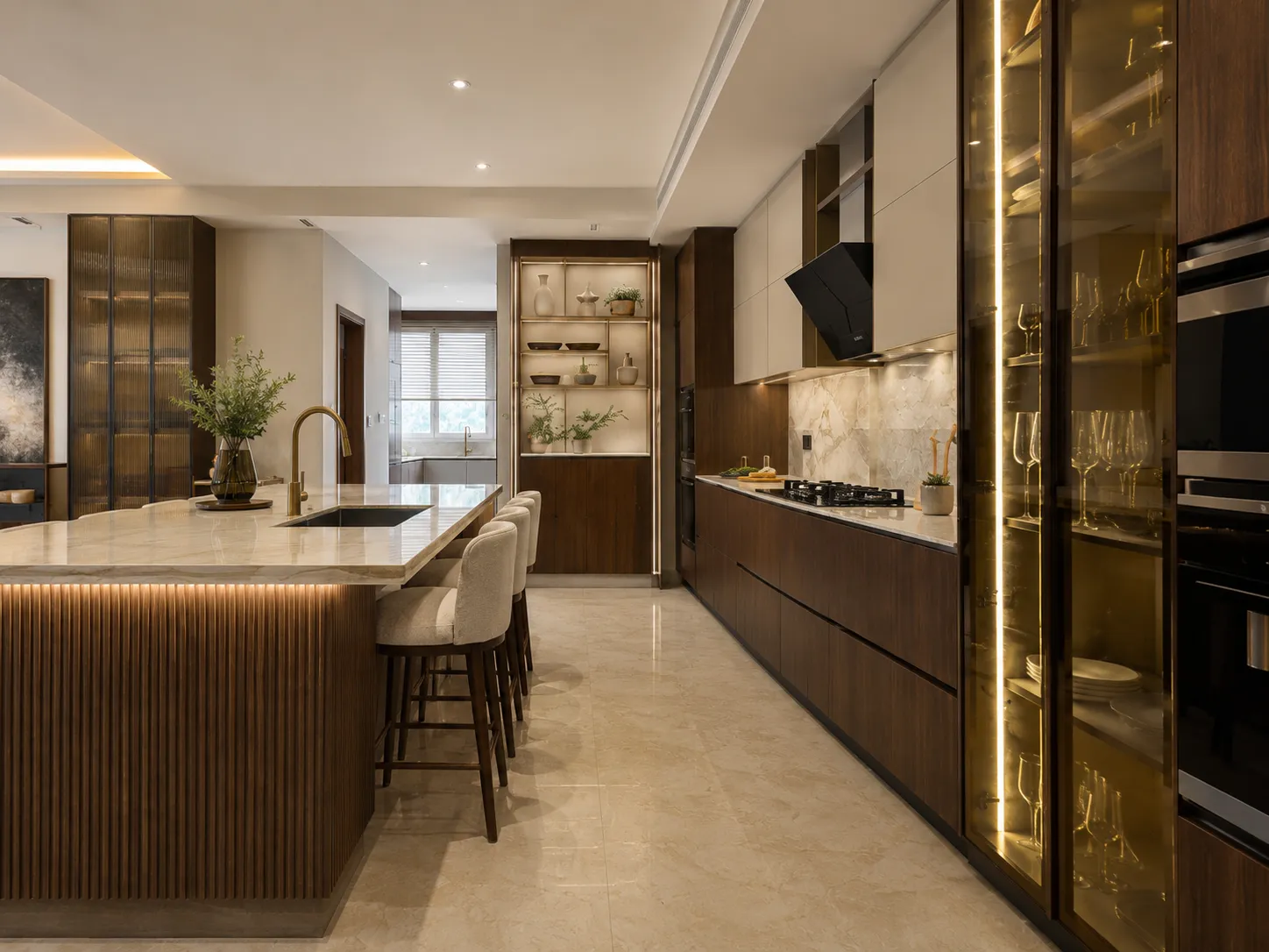 Main kitchen cooking zone showing dark wood lower drawers, a black angled range hood, and a tall illuminated glass cabinet displaying wine glasses.