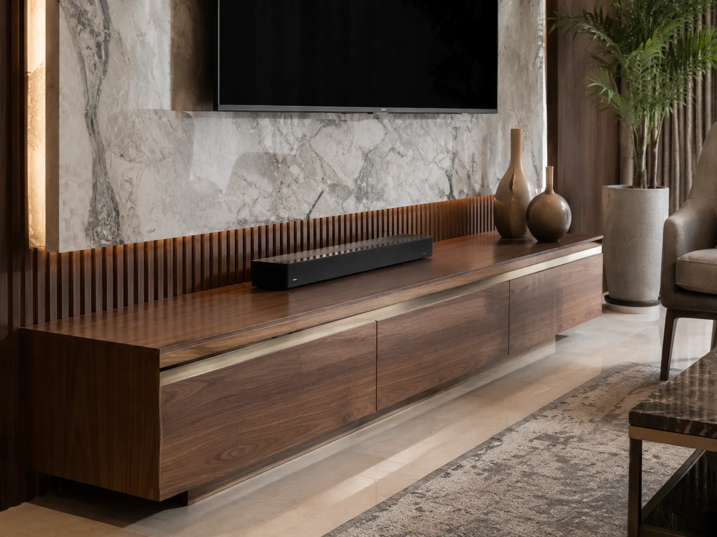 Close-up of a walnut-finish wooden TV console with brass trim, set against fluted wood paneling and a large grey and white marble slab.