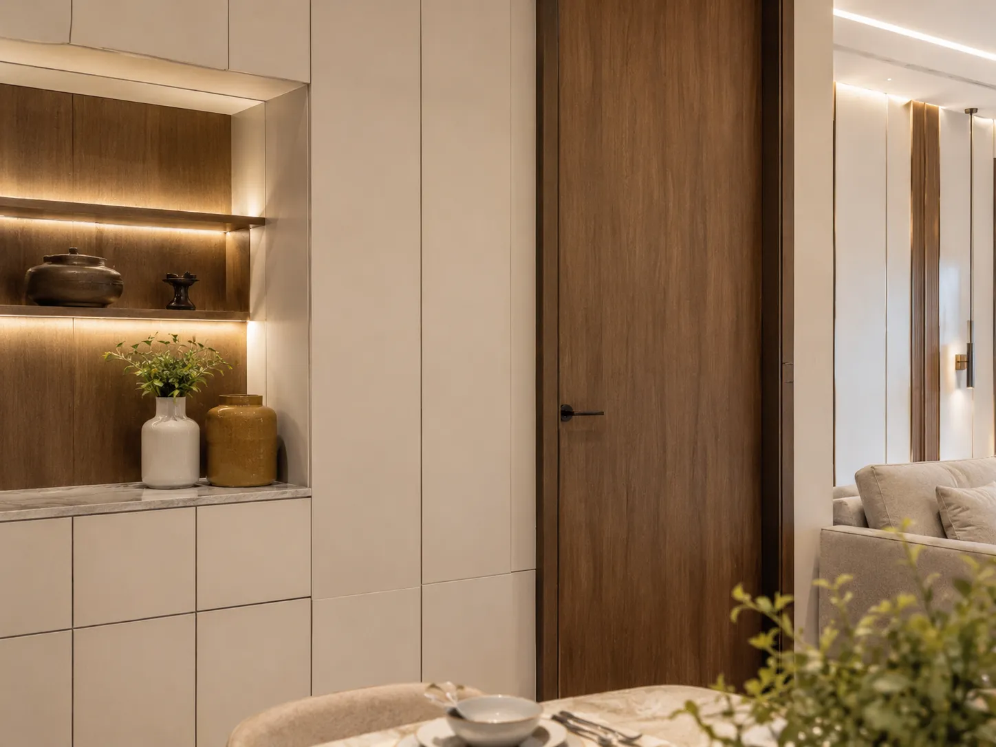 Close-up of a floor-to-ceiling flat-panel wooden door next to built-in beige cabinetry with an illuminated wood display niche.